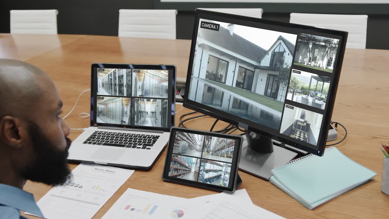 oficial de seguridad afroamericano viendo las vistas de las cámaras de cctv en pantallas de computadora, cámara lenta