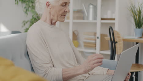 mujer mayor usando una computadora portátil en casa