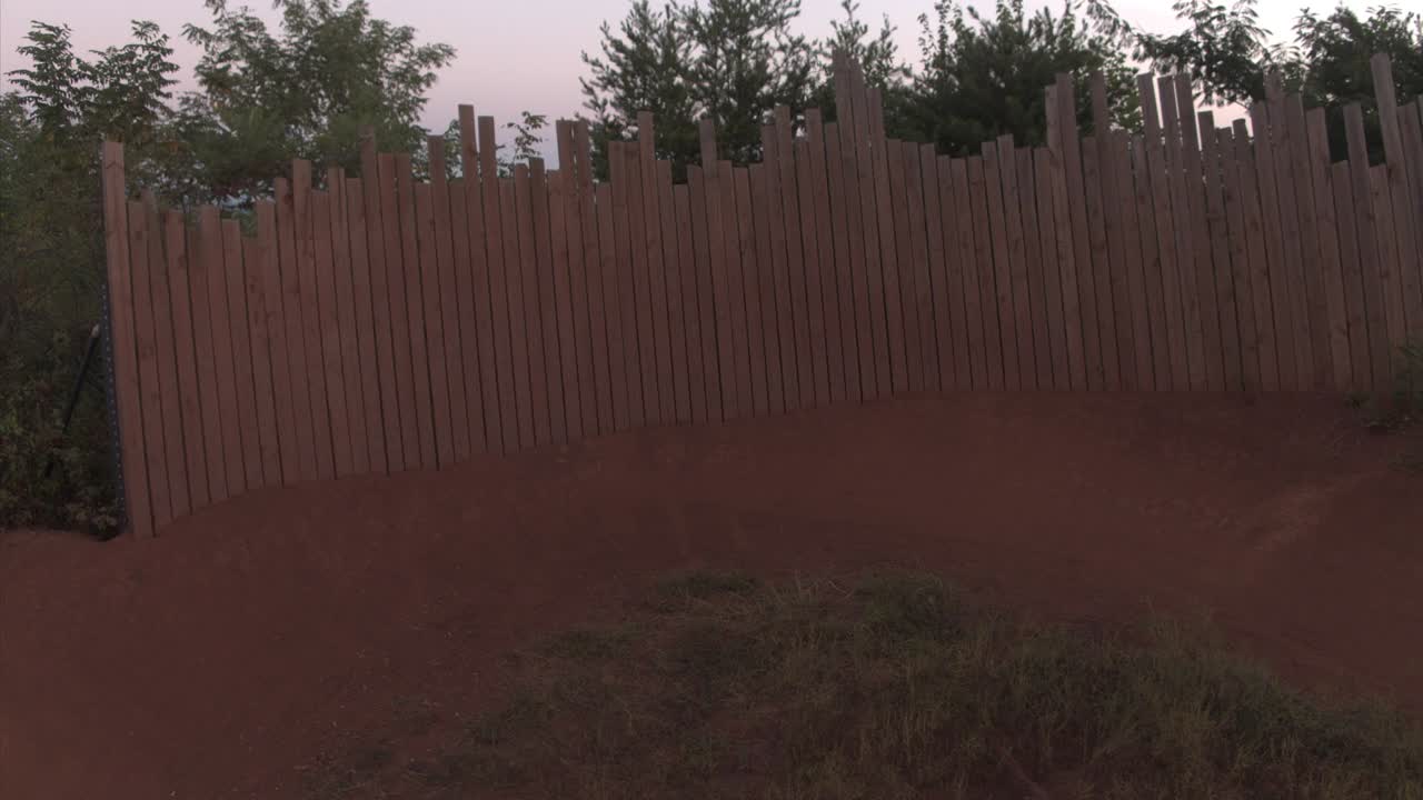 - un piloto de bicicleta de montaña gira alrededor de una esquina de pared alta