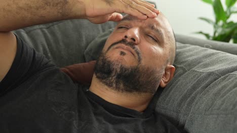 hispanic man, stressed out or headache on couch