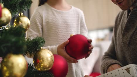 Handheld-view-of-girl-and-her-daddy-decorating-Christmas-tree