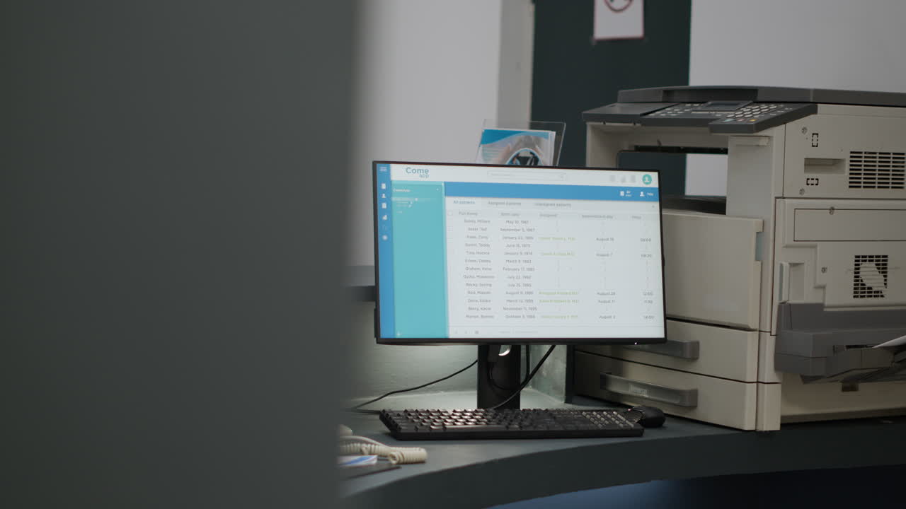 Doctor's office reception area with computer displaying patient list and appointments