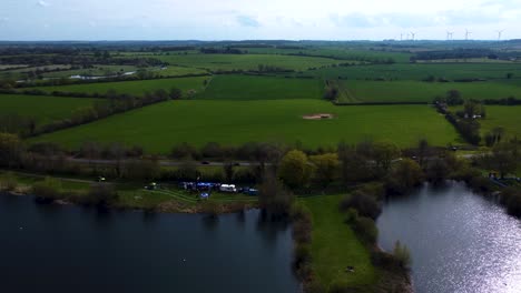 4K-aerial-drone-footage-of-green-files-and-crop-farmland-fields-English-countryside-village-in-the-summertime,-UK