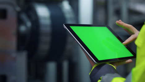 Hands-scrolling-greenscreen-tablet-computer-on-modern-production-factory.