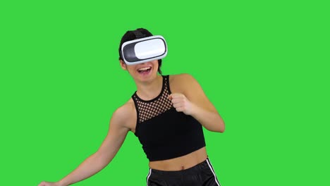 happy smiling young girl using vr headset glasses playing dancing game first time on a green screen, chroma key