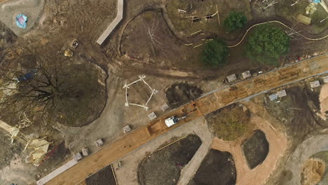 an aerial shot of an building construction taking place with construction vehicles