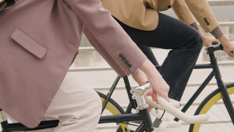 close up of unrecognizable man and woman riding bikes on the city bridge