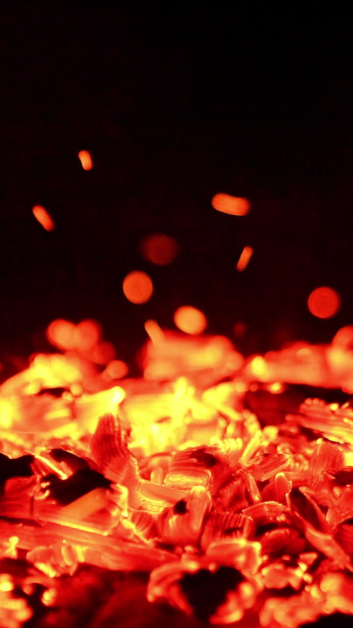 Burning logs close up view. Red flaming on a firewood. Vertical video