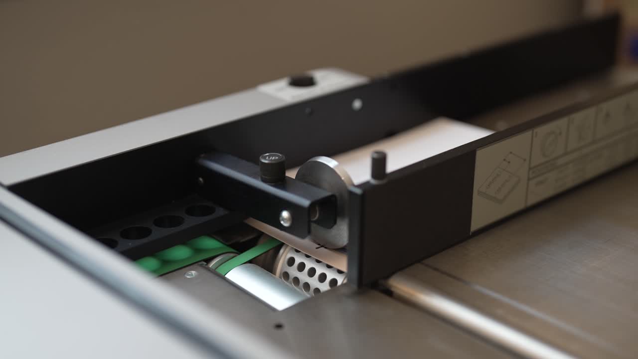 산업용 접는 기계가 접힌 인사말 카드에 점수를 매깁니다.