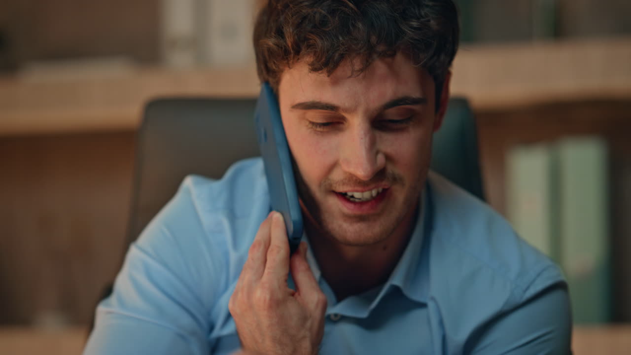 Consultant calling cellphone late evening at office closeup. Smiling businessman