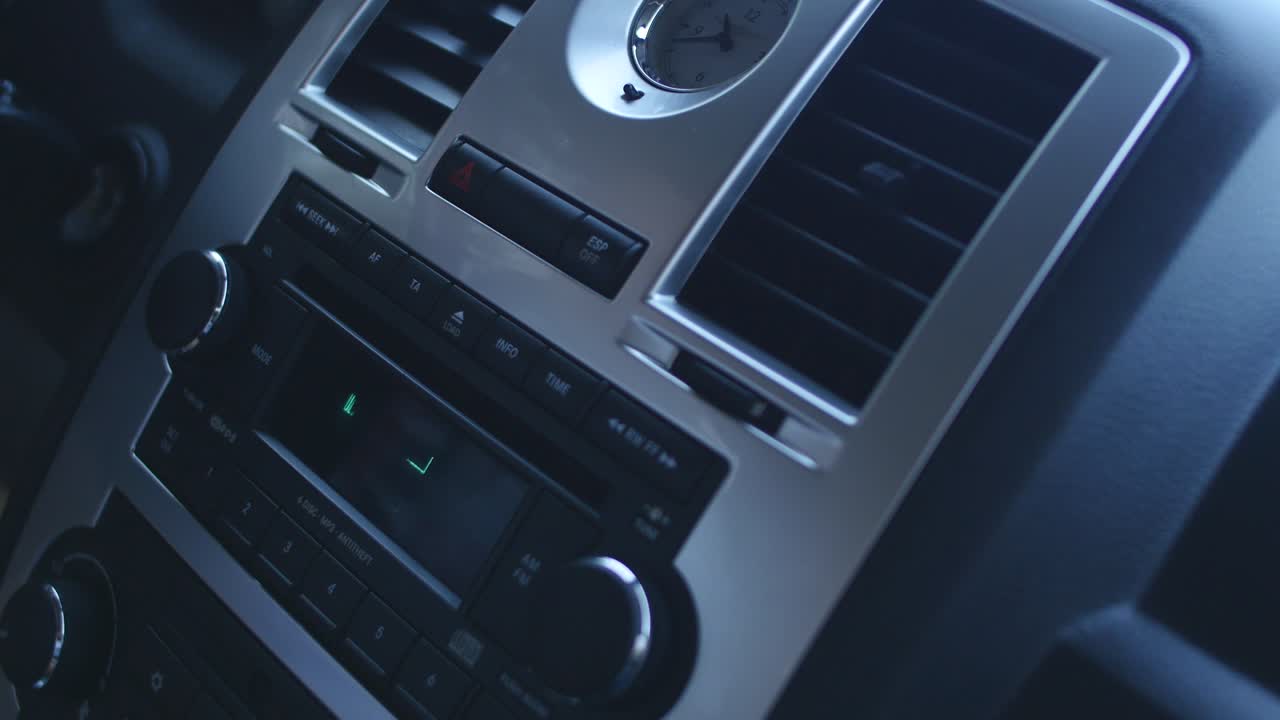 conductor tocando la radio del coche, cambiando de estación