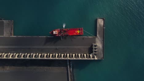 red cargo ship moored at pier of tazacorte harbor in la palma island