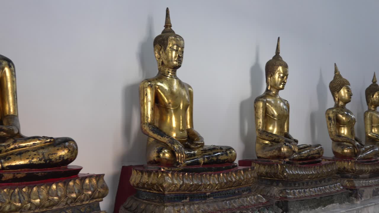 Golden Buddha statues at Wat Pho temple in Bangkok, Thailand. Traditional Thai craftsmanship symbolizes peace, spirituality, and Buddhist heritage