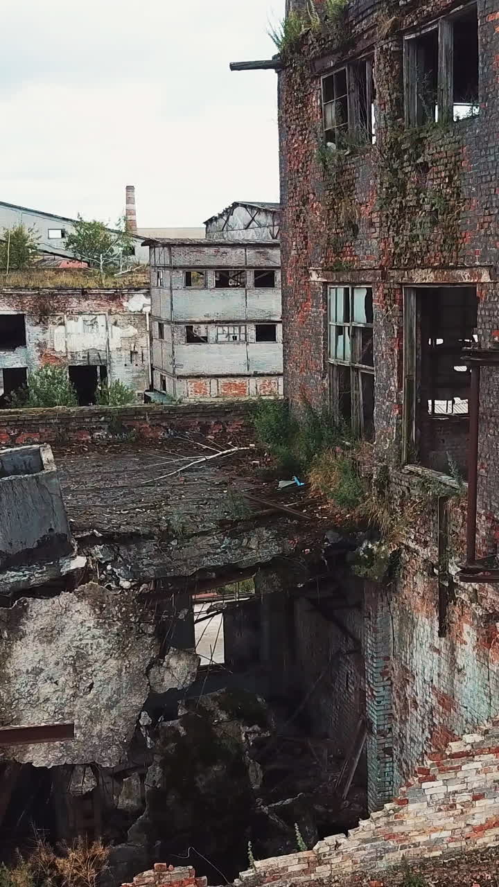 Ruins of an old factory. Old industrial building for demolition. Aerial view. Vertical video