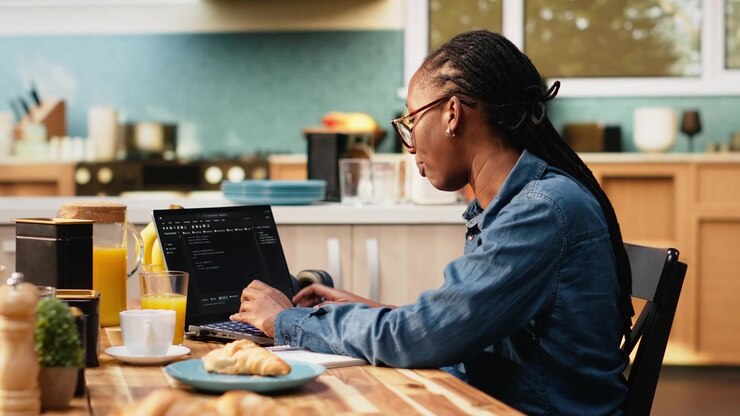 Adult woman using laptop to write programming code and develop software