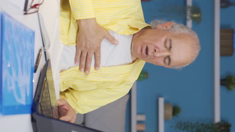 vertical video of home office worker old man suffering from shortness of breath.