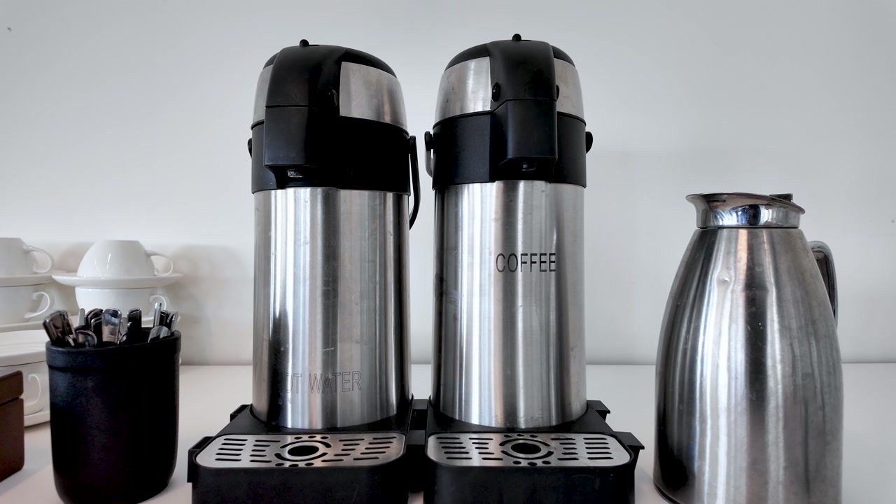 Stainless steel thermal dispensers providing coffee and hot water for a corporate meeting setup