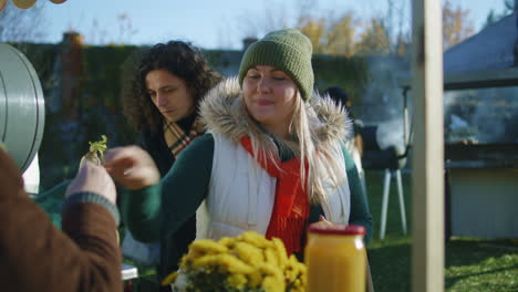 adult woman chooses apples at the stall adult woman chooses apples at the stall with fruits and vegetables people walking and shopping on background local farmers market or fair outdoors vegetarian and organic food agriculture