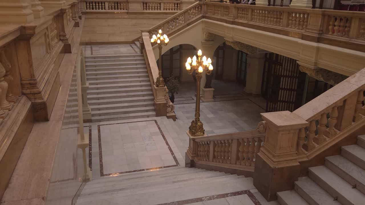 A shot inside the municipal palace of Lima, Peru. A historical building dating back to colonial times. Stone floors and stairs can be seen and also two lit lamps
