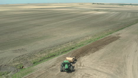 panorama de un tractor cargado con tierra conduciendo en el vasto paisaje en saskatchewan, canadá