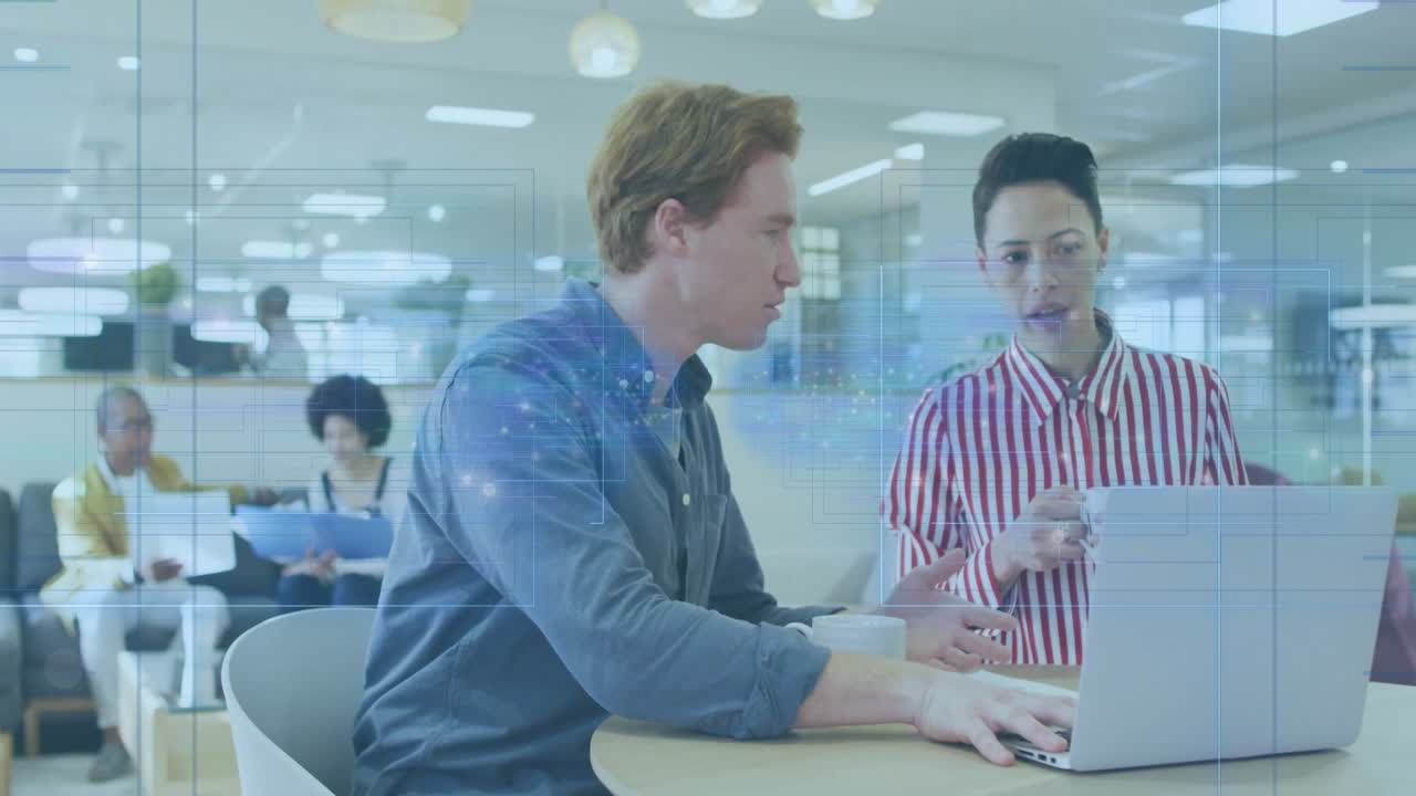 Coworkers typing on laptop in modern office lounge, showing animated business graphs