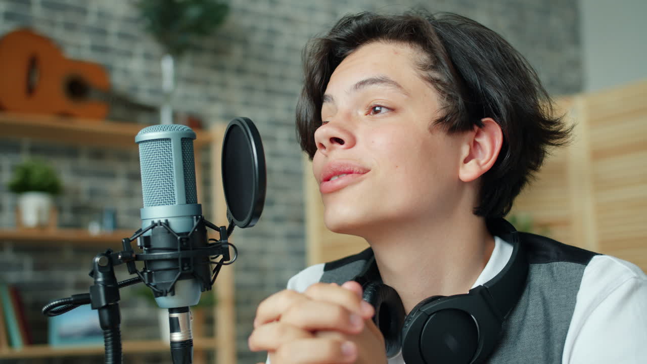 Teenage Musician Singing into a Microphone in a Home Recording Studio