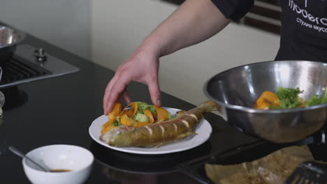 chef preparando trucha asada con verduras