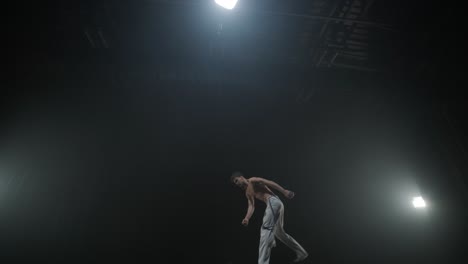 acrobacias de capoeira en un estudio oscuro