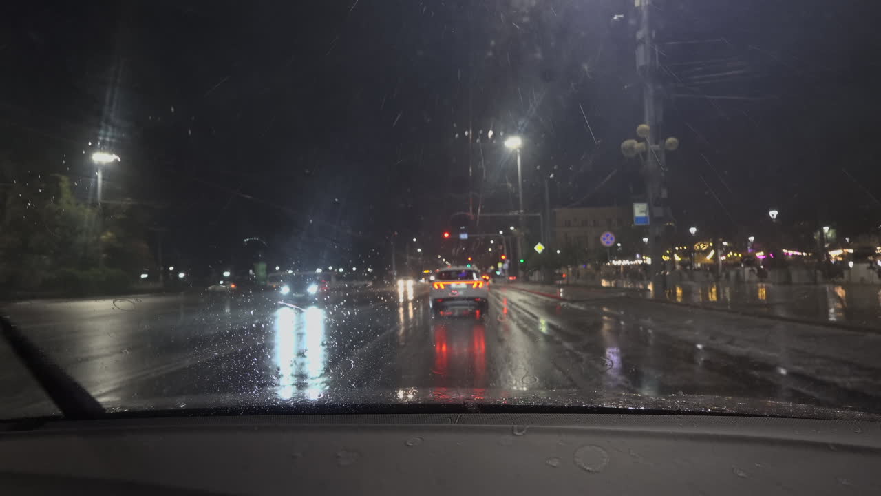 Chisinau, Moldova - June 7, 2025: View from the windshield of a moving car on the streets of the city on a rainy evening