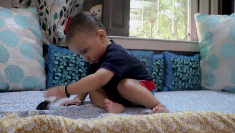 cute-toddler-with-innocent-serious-facial-expression-sitting-at-couch-at-home