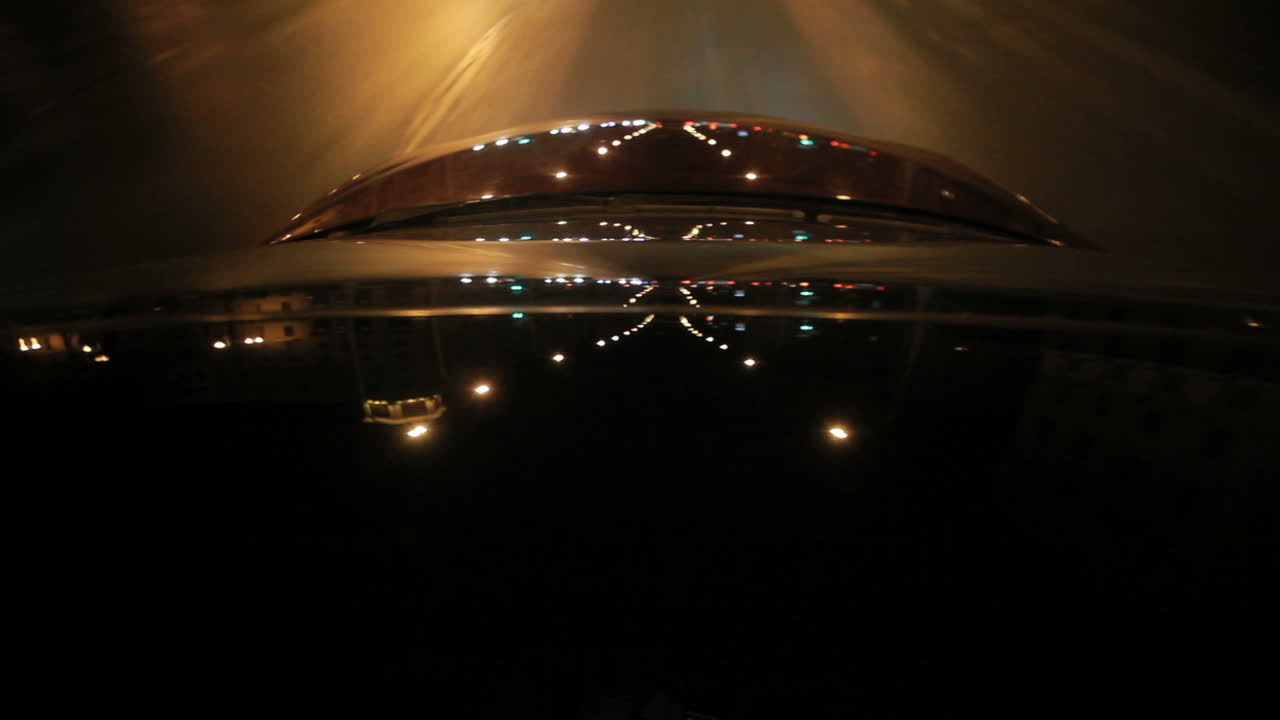 reflejos de luz en el techo y el capó de un automóvil en movimiento en la ciudad nocturna