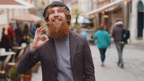 happy cheerful young man showing ok gesture positive like sign approve something good celebrate
