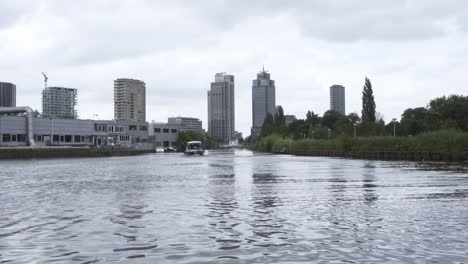 boat in the distance with a beautiful view of the amsterdam skyline
