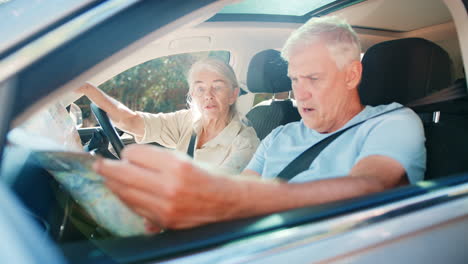 senior couple in car with map arguing about directions on day trip out