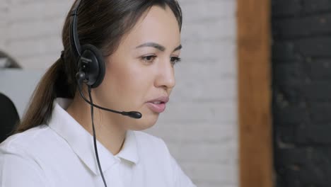 smiling woman call centre operator, customer support agent wears headset consults client online typing on laptop, talk in internet computer chat, helpline operator secretary make conference video call