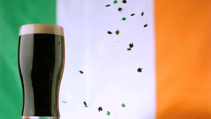 Shamrock confetti falling beside pint of stout