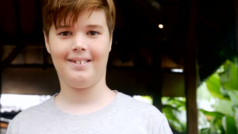 retrato de un niño de 12 a 13 años con pecas sonriendo