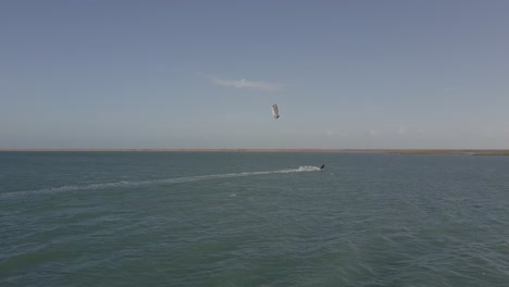 Drone-following-a-Kite-Boarder-in-Ilha-do-Guajiru,-Brazil