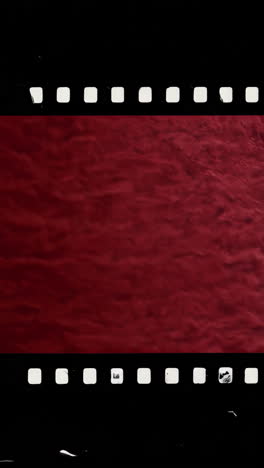 dark red abstract background with vintage film strip frame