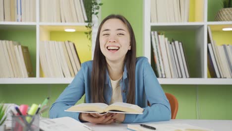 portrait of funny and playful happy asian teenage schoolgirl reading a book.