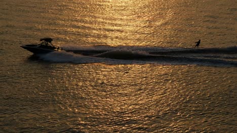 esquí acuático en la superficie del mar del atardecer dorado