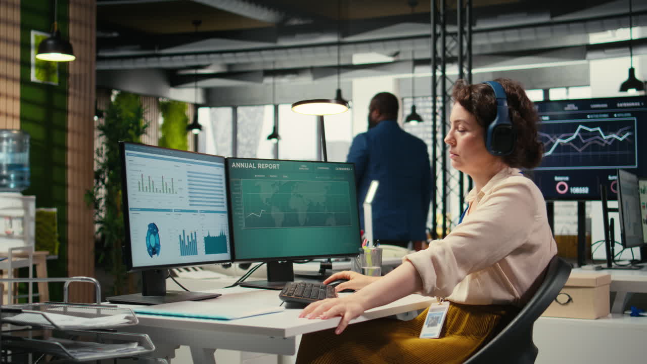 Vertical Video Young businesswoman focused on a podcast while she resolves office tasks