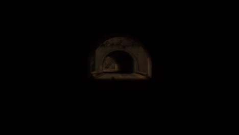 warm pov take of driving through a mountain tunnel in the summer of 2020.