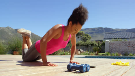 Mixed-race-young-woman-doing-exercise-in-the-backyard-of-their-home-4k