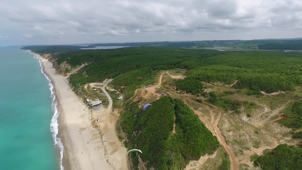Paragliders Flying Over Green Hills Drone Footage
