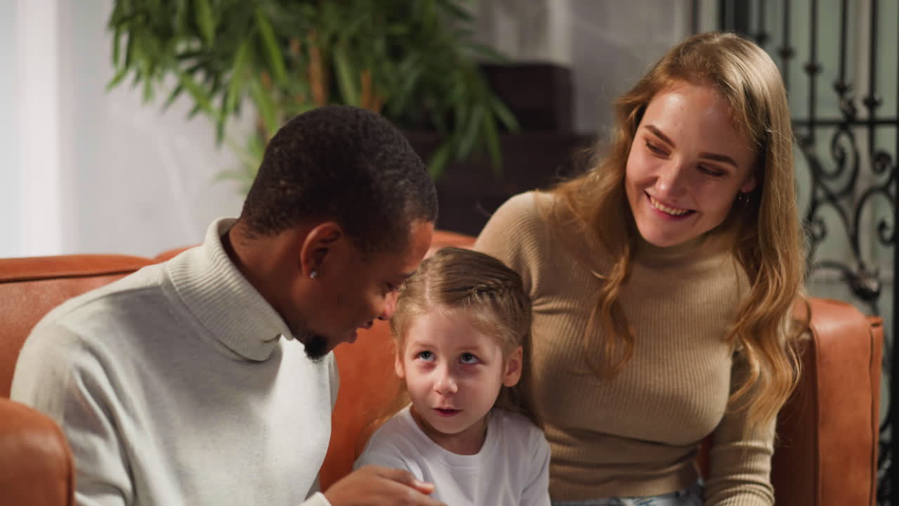 한 소녀 가 어머니 와 함께 방문 한 남자 에게 가족 에 대한 질문 을 한다