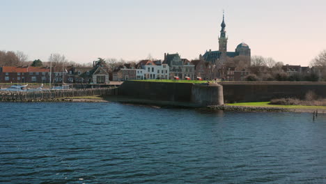 Aerial:-The-historical-town-of-Veere-with-an-old-harbour-and-churches,-on-a-spring-day