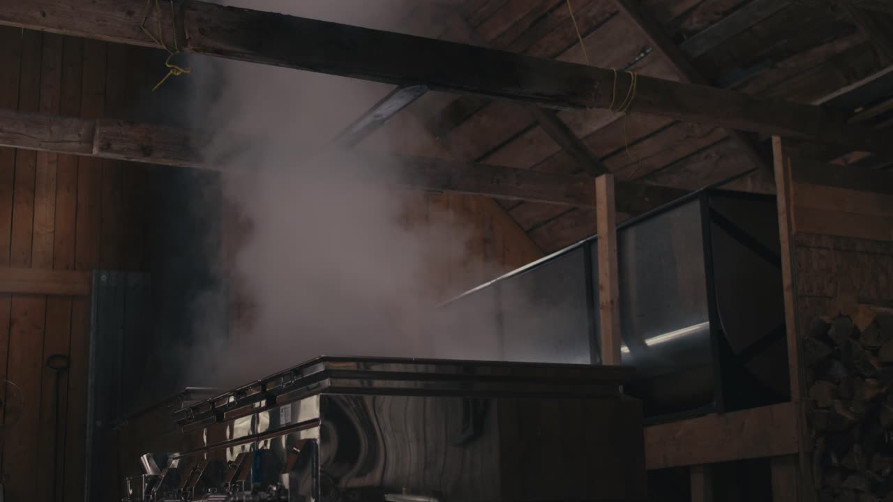 vapor de jarabe de arce en el evaporador cocinando dentro de la choza de azúcar en canadá