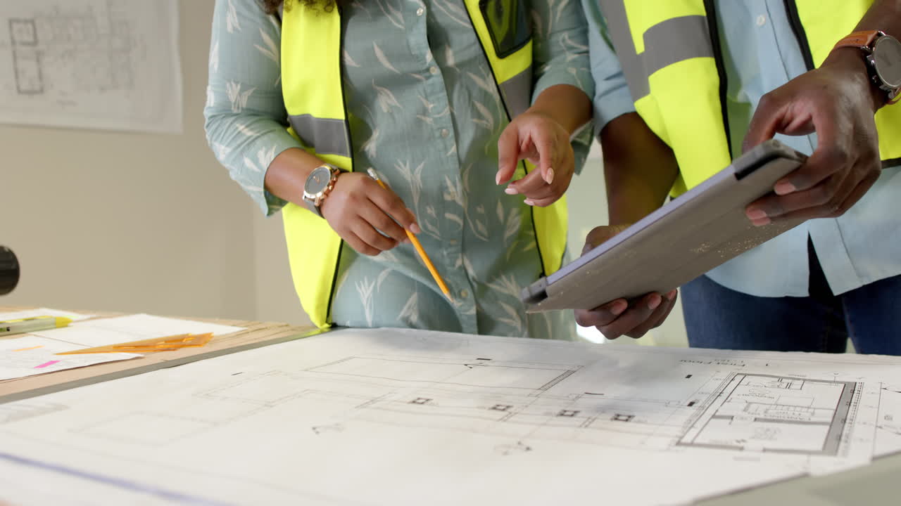 arquitectos diversos casuales mirando planos en la oficina, cámara lenta con espacio de copia