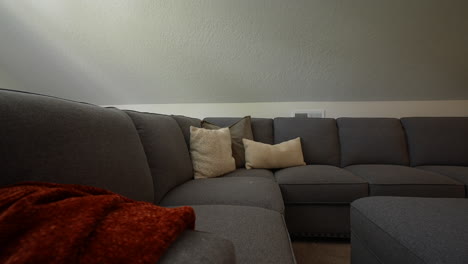 sofá gris en el loft adicional de la sala de estar con almohadas y una manta, área para pasar el rato, sala de estar